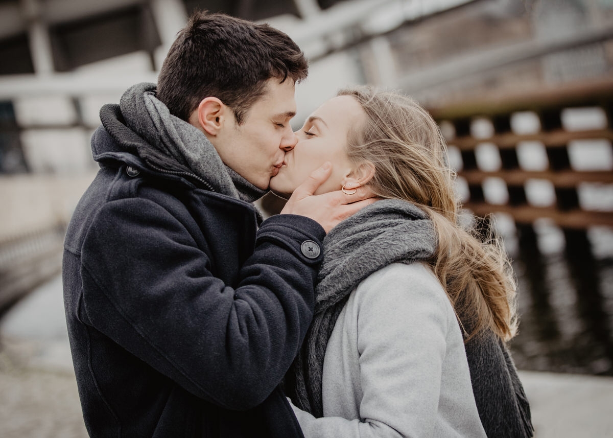Ein junges Paar küsst sich innig. Er hält ihr Gesicht liebevoll mit seinen Händen umfasst. Fotografin: Claudia Nürnberger
