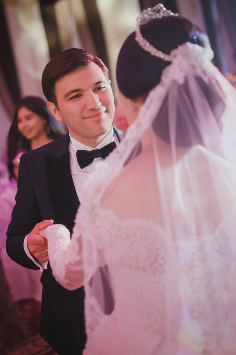 Bräutigam schaut beim Tanzen verliebt seine Frau an. Beide halten sich die Hände. Fotografin: Claudia Nürnberger 